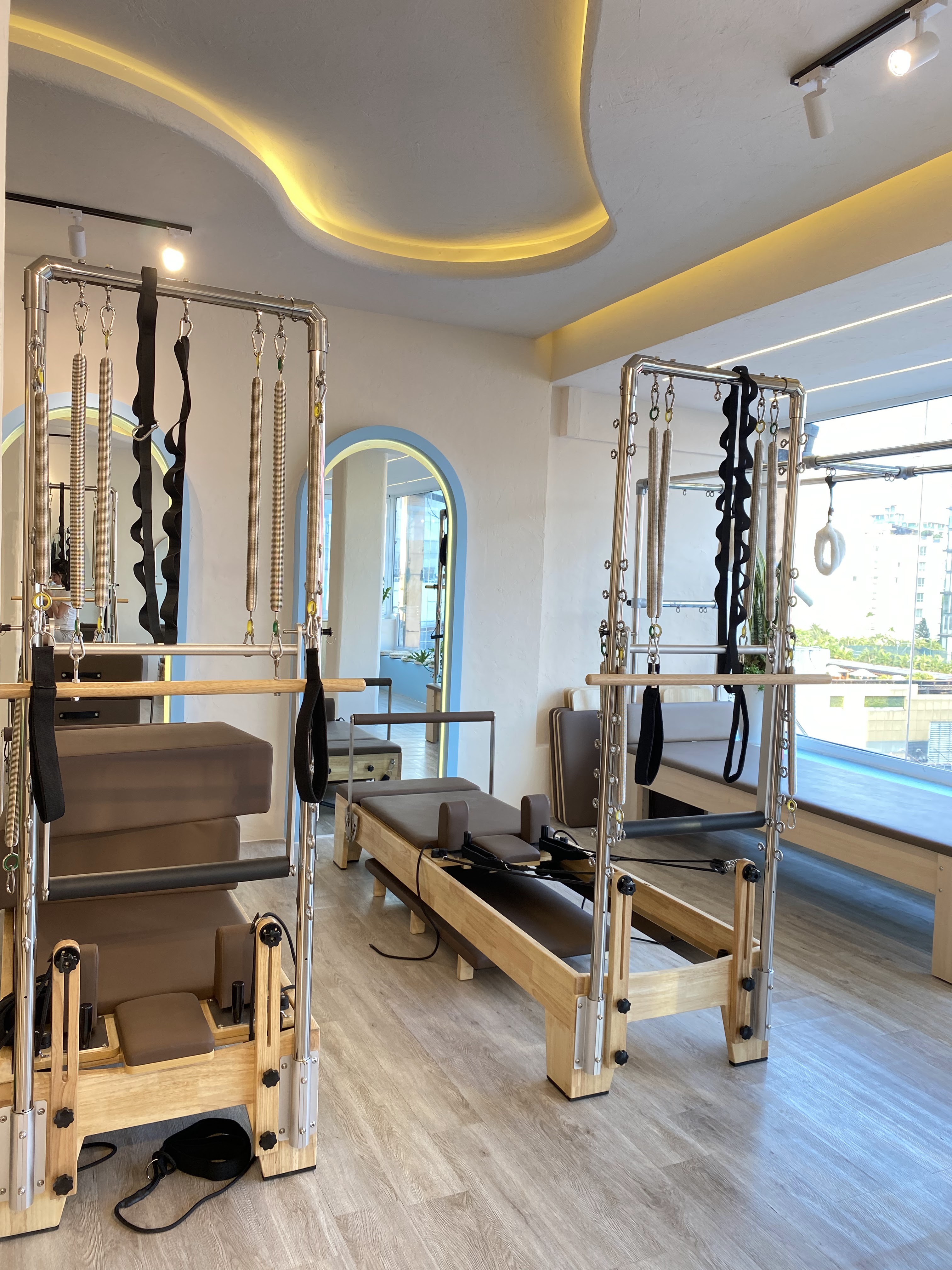 Khu máy Pilates trong studio Aurise với trần bo cong và ánh đèn vàng